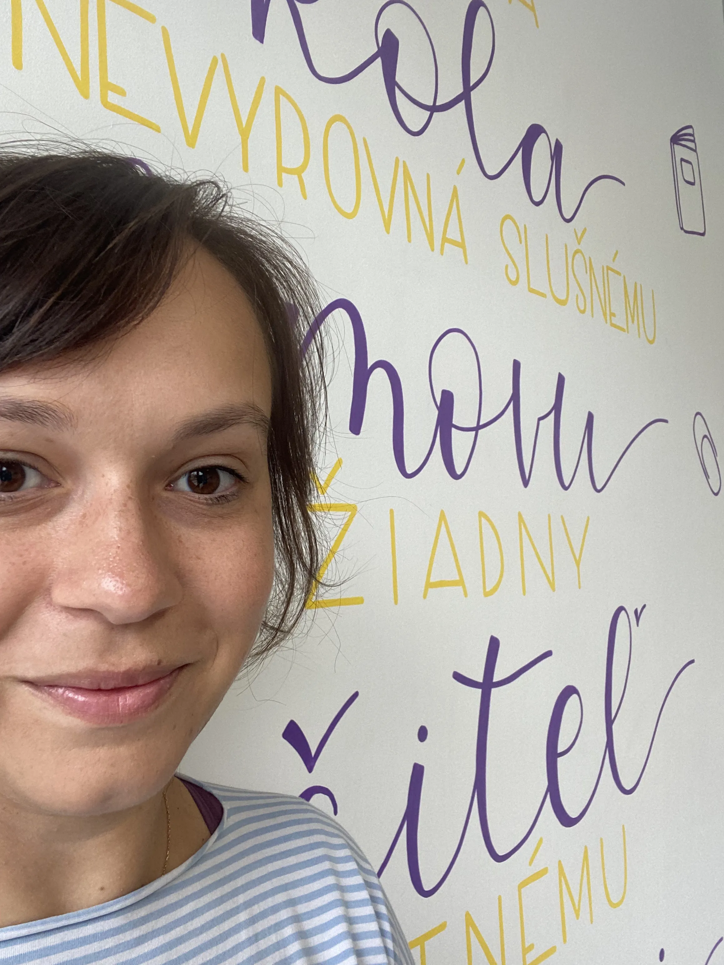 Selfie pred stenou pokrytou ručným písmom v žltej a sivej farbe