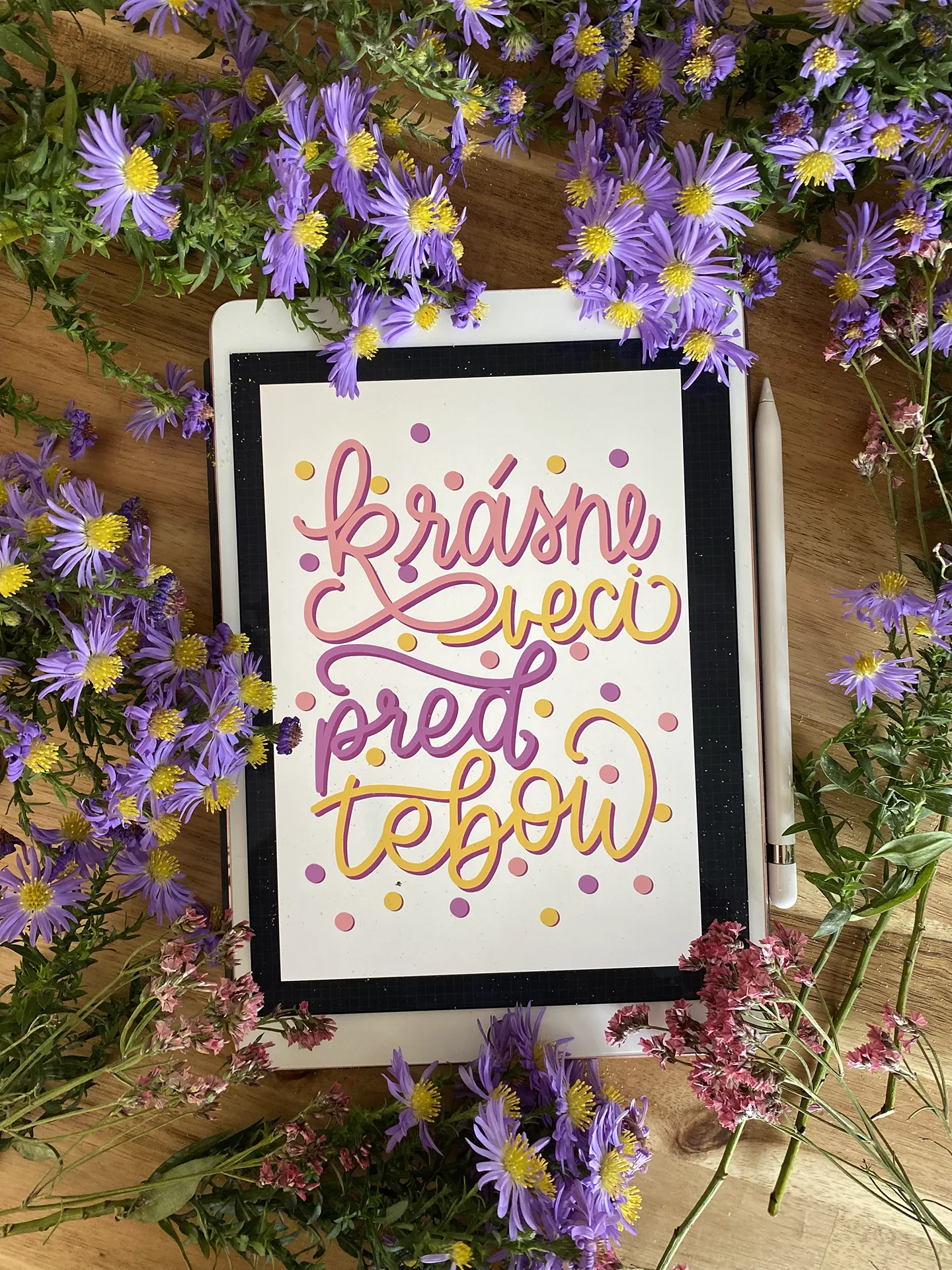 Rámovaný ručný nápis v pastelových farbách uprostred fialových kvetov