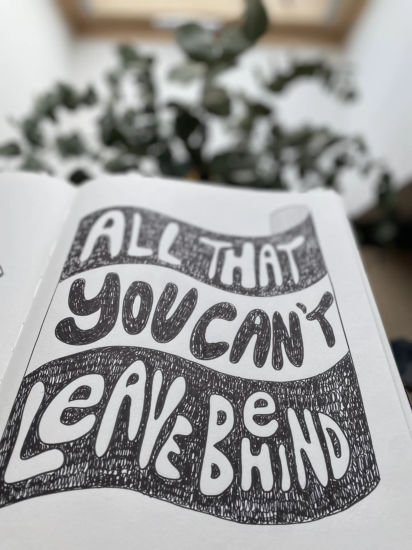 Ručný nápis „ALL THAT YOU CAN’T LEAVE BEHIND“ v čiernobielej typografii