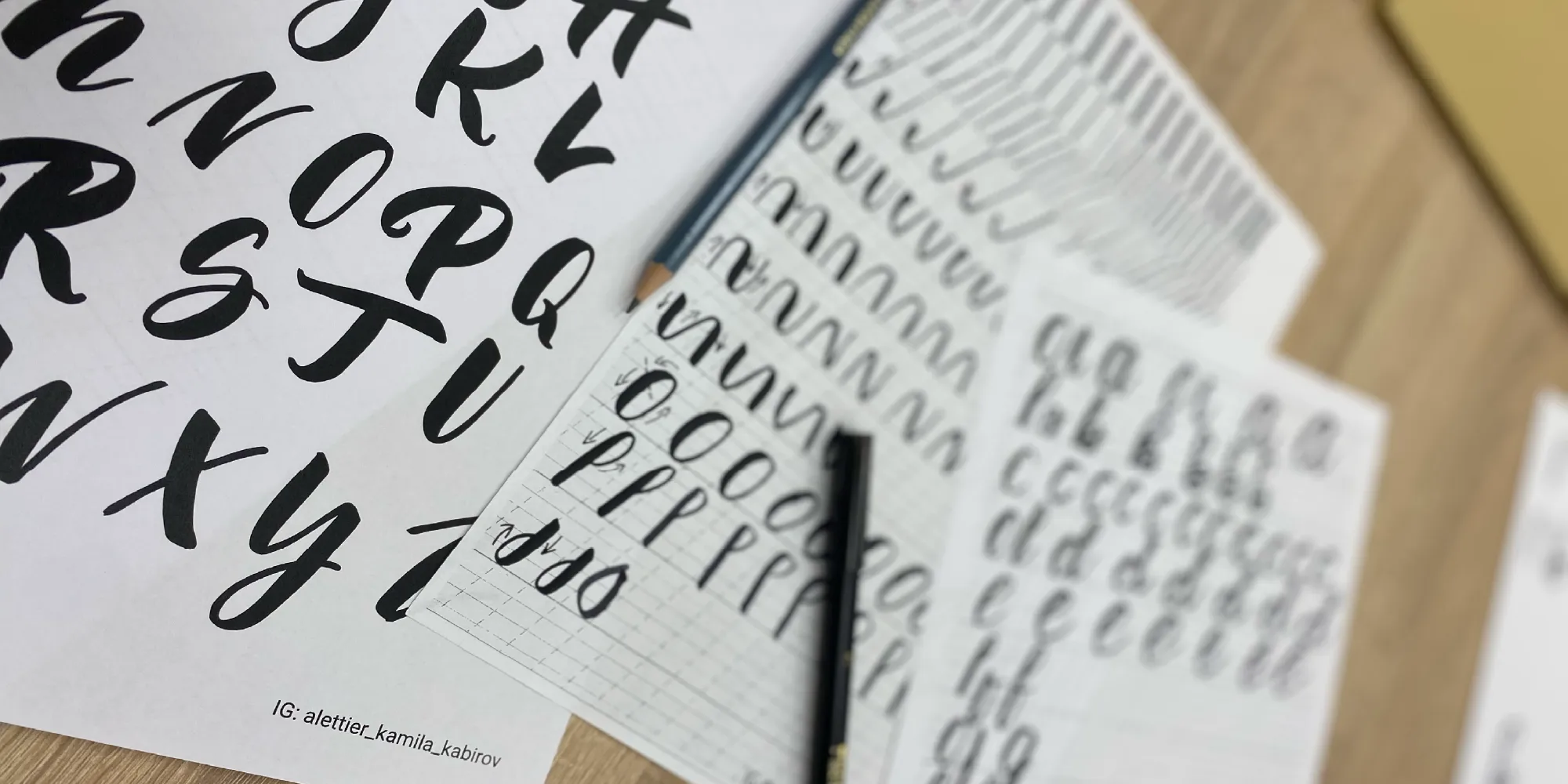 Detail pracovných listov s ukážkami ťahov štetcom a abecedy na workshop